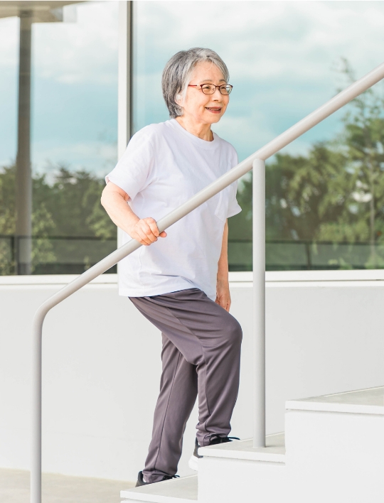 元気に階段を登る年配の女性