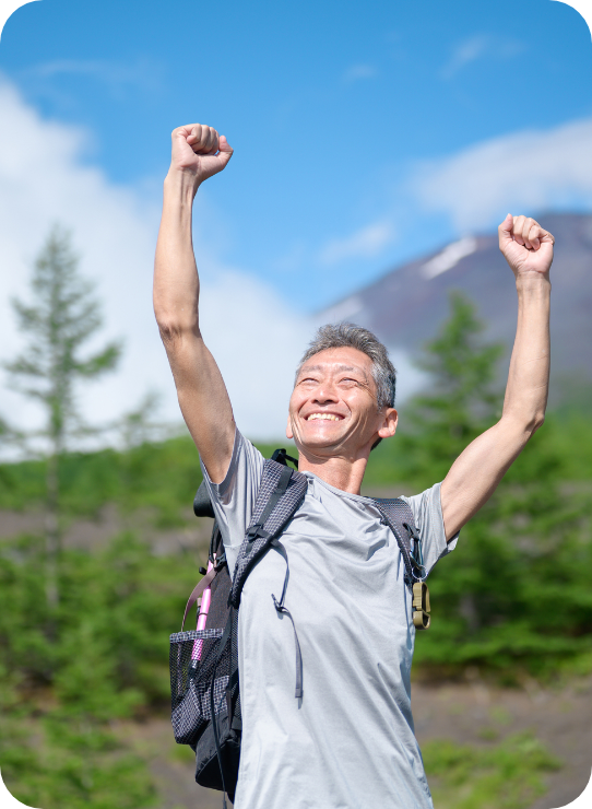 登山に成功したガッツポーズの50代男性