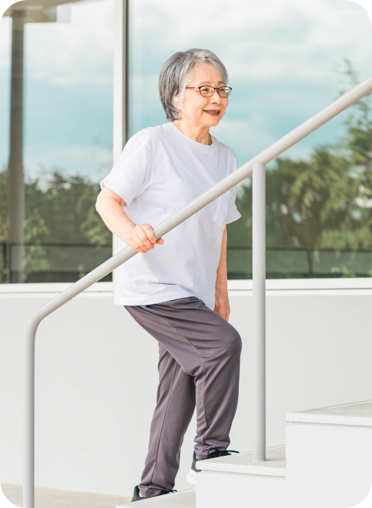 元気に階段を登る年配の女性