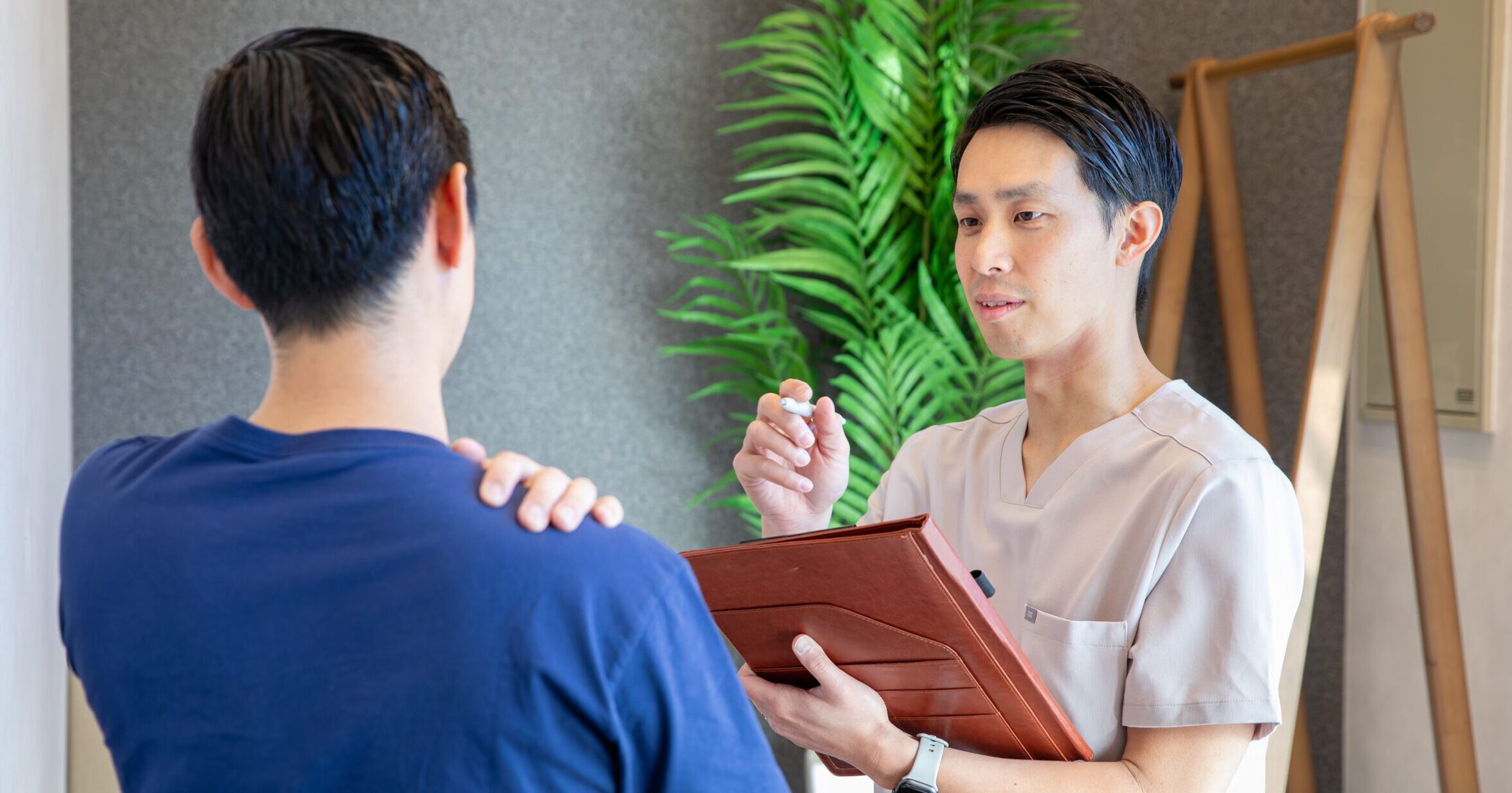 トレーナーがタブレットを使い、利用者にカウンセリングを行っている様子