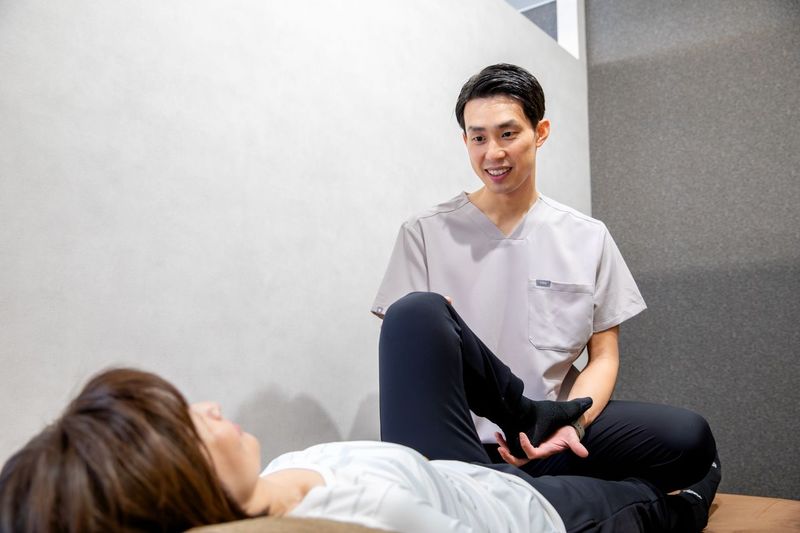 股関節のストレッチをサポートするトレーナー