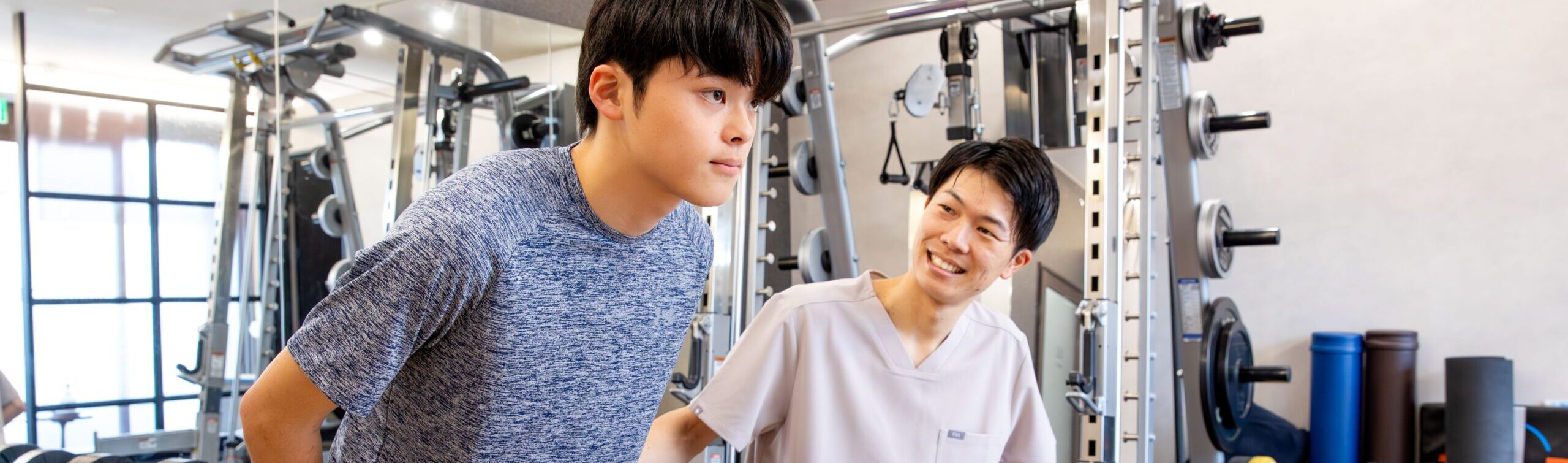 ボールを使ったトレーニングをする男の子とトレーナー