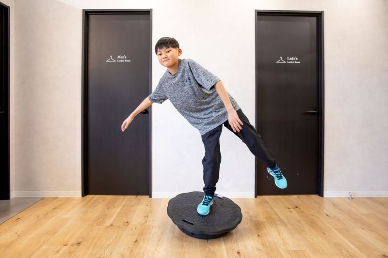 バランスボールに乗ってトレーニングする子ども