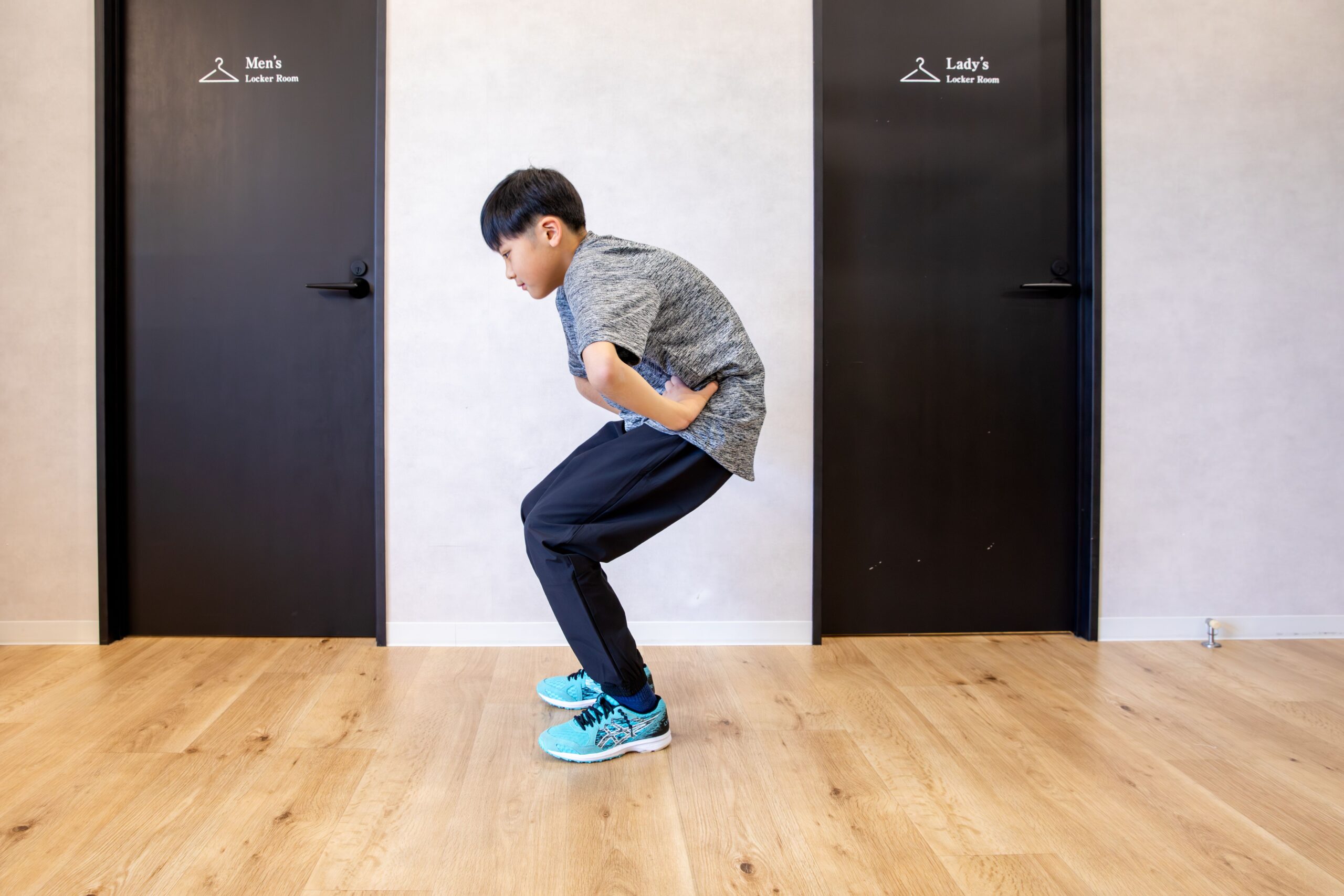 軽く膝を曲げ、上体を前に倒した姿勢をとる子ども